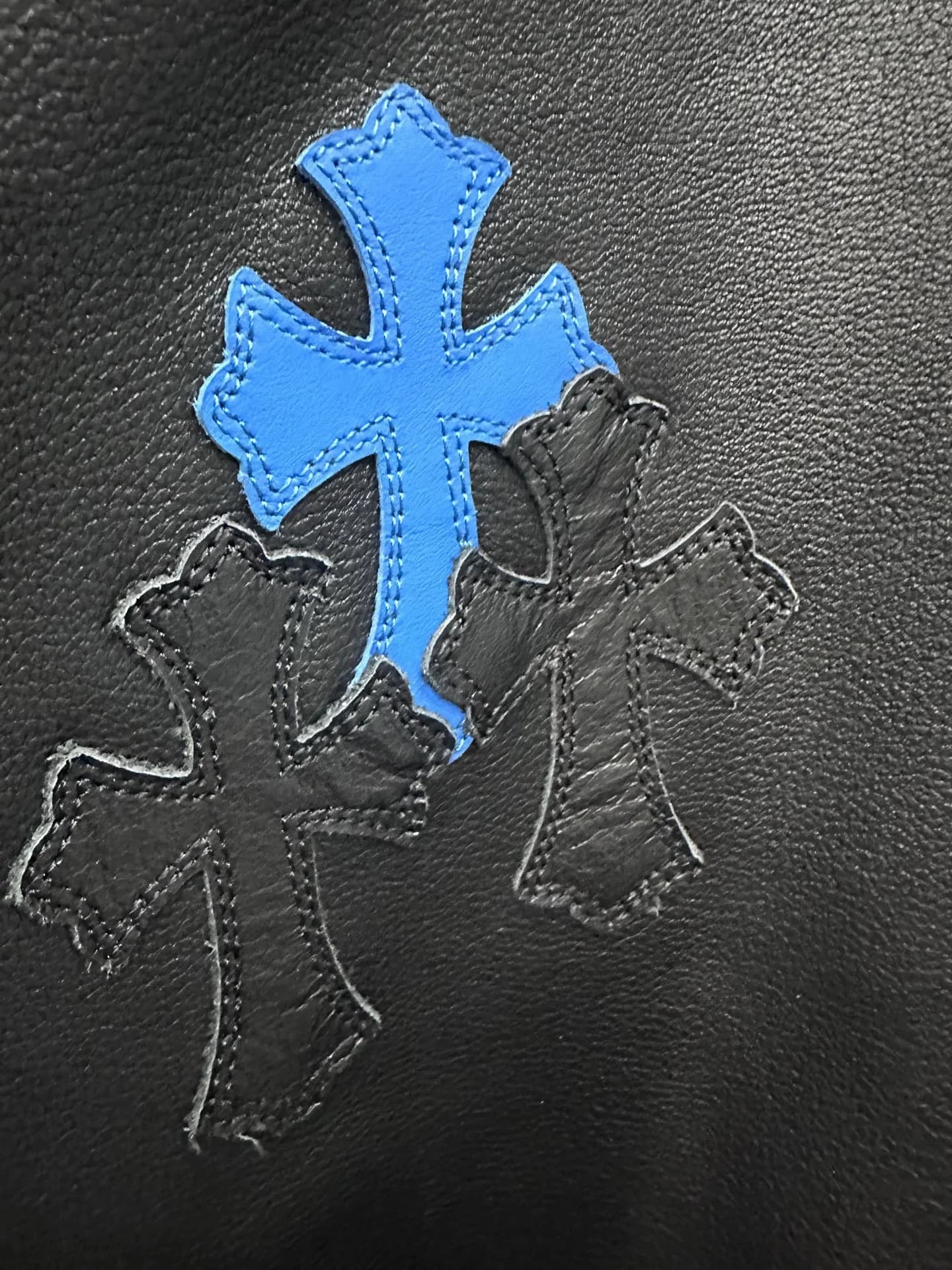 Декоративные нашивки в виде синего и черного кожаных крестов на брюках Chrome Hearts