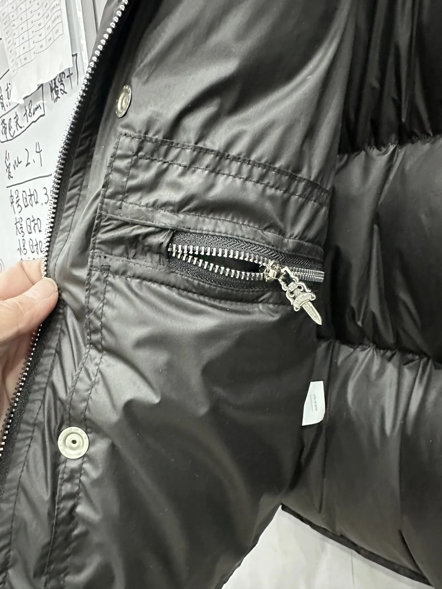 Деталь пуховика Chrome Hearts: внутренний карман на молнии с серебряным пуллером