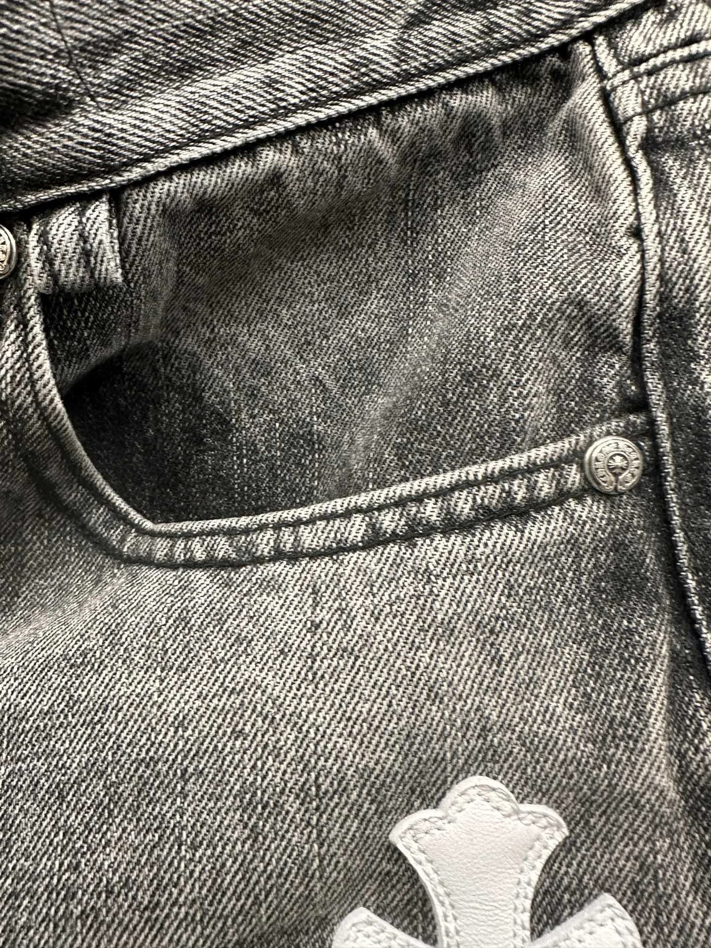 Деталь передней части джинсов Chrome Hearts с белой кожаной нашивкой