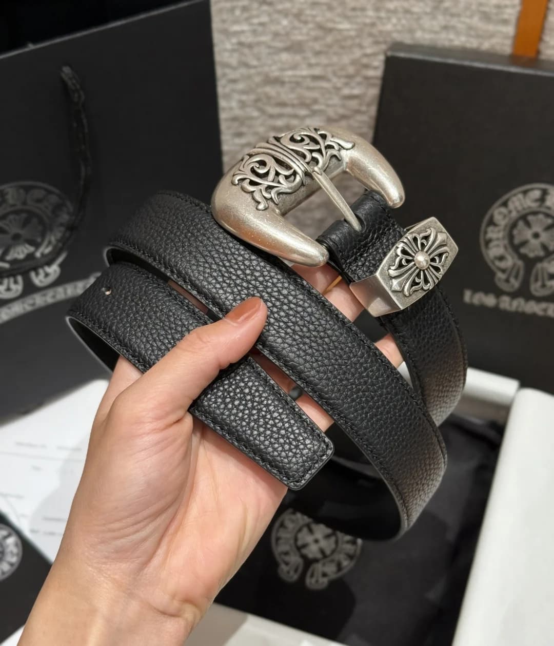 Свернутый кожаный ремень Chrome Hearts в руке