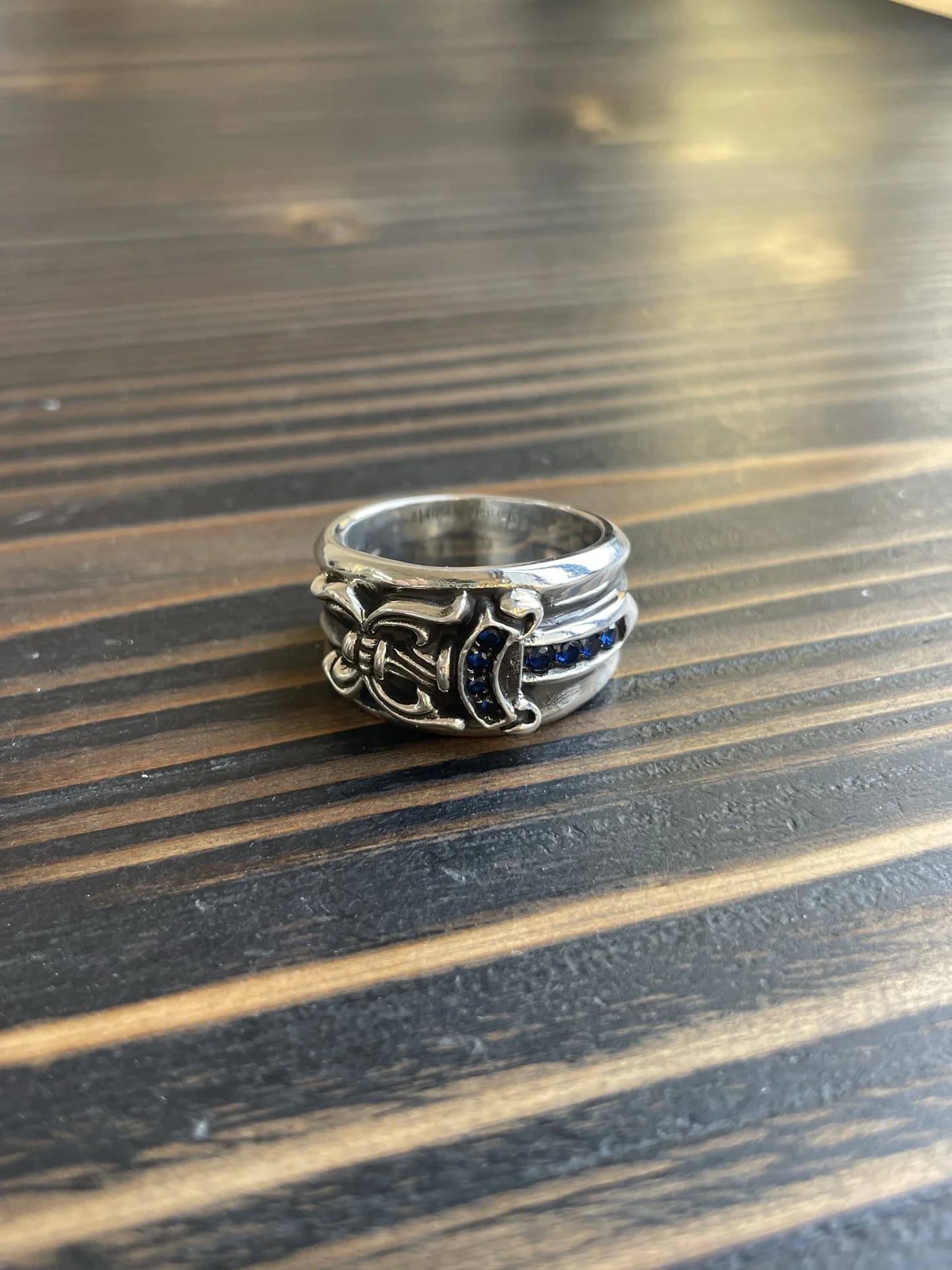 Серебряное кольцо Chrome Hearts Dagger с синими бриллиантами на деревянной поверхности