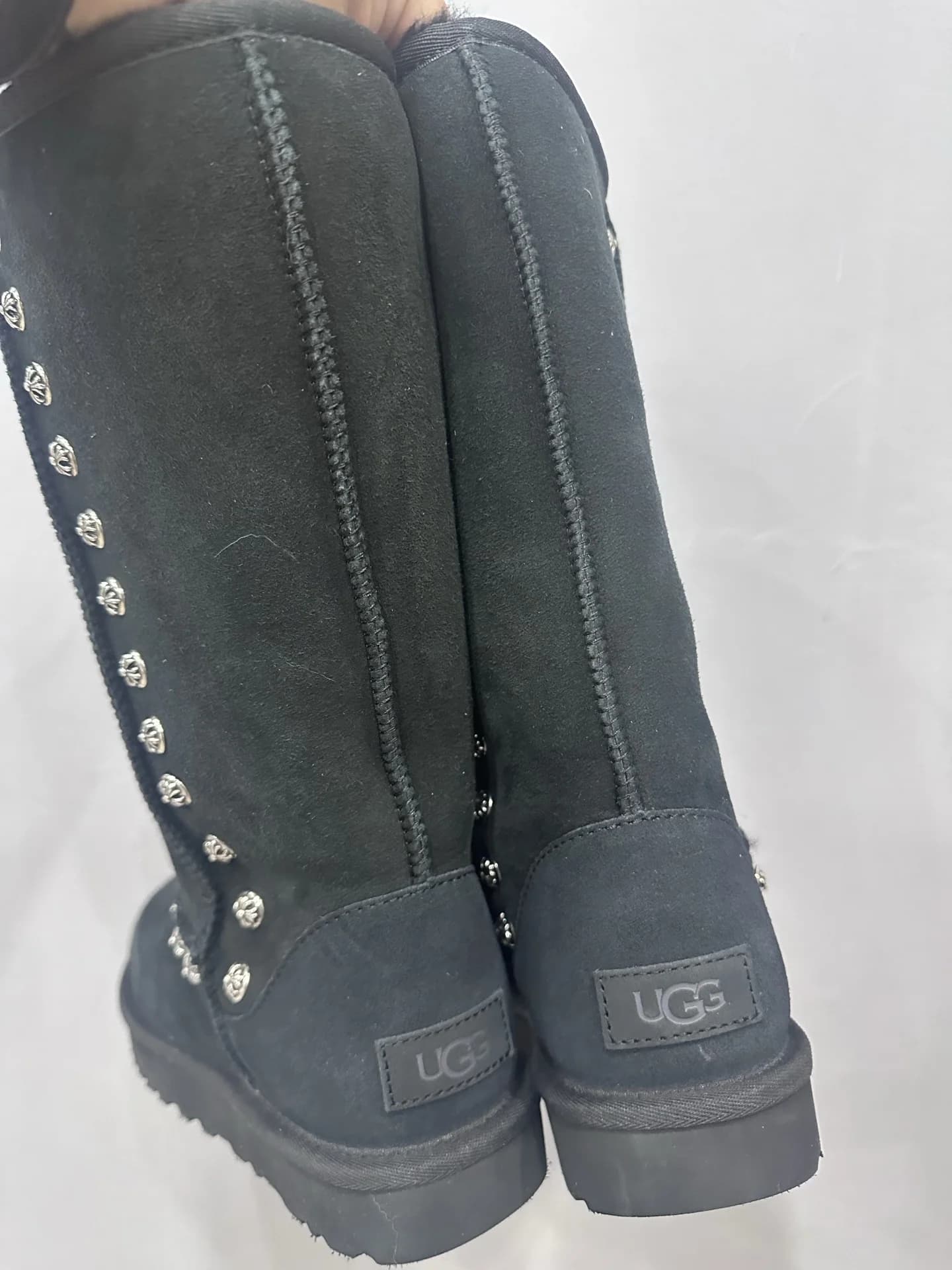 Вид сзади на высокие черные угги Chrome Hearts x UGG Classic с логотипом UGG на пятке