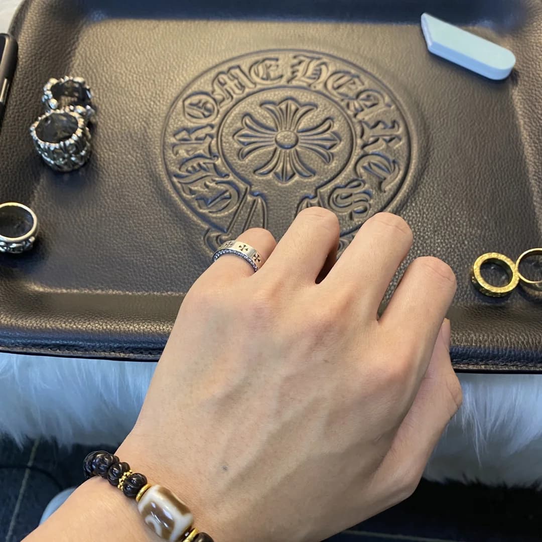 Кольцо Chrome Hearts Forever на пальце на фоне кожаного лотка