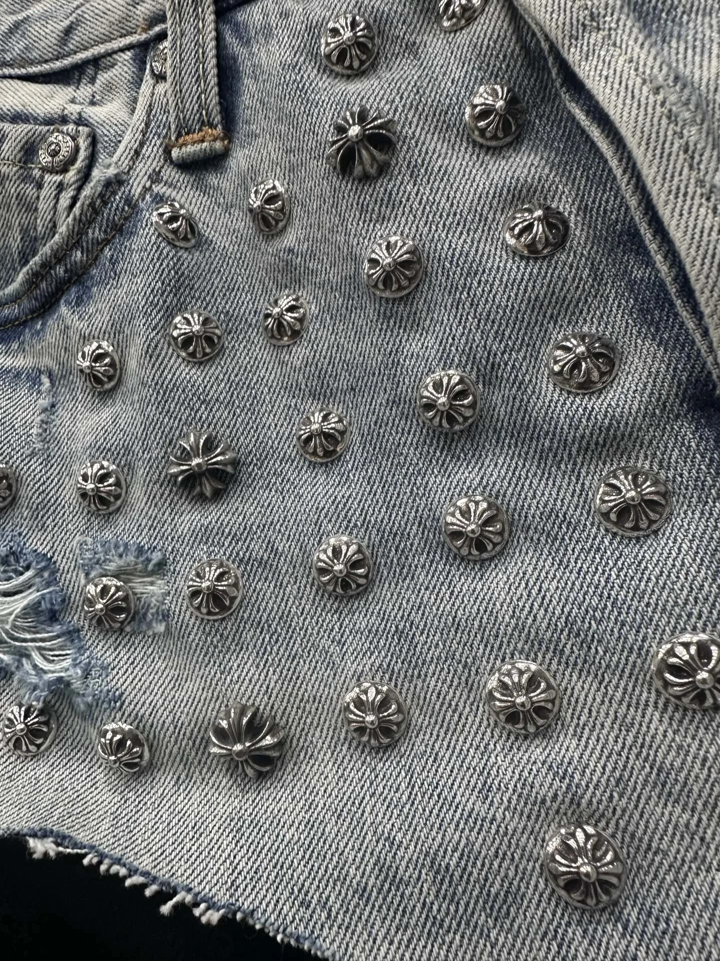 Деталь отделки: серебряные заклепки-кресты на джинсовых шортах Chrome Hearts
