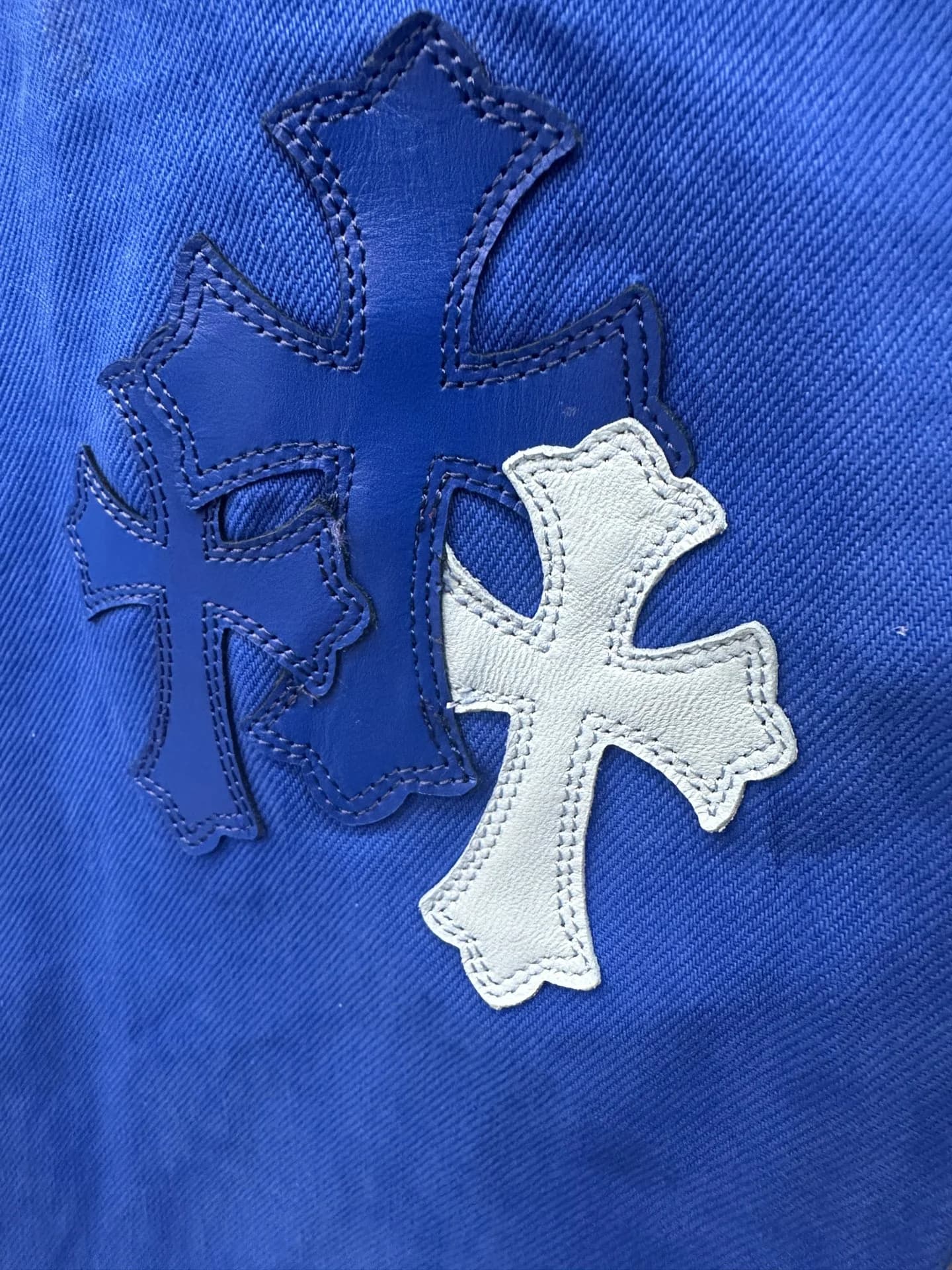 Деталь с кожаными нашивками-крестами на джинсах Chrome Hearts