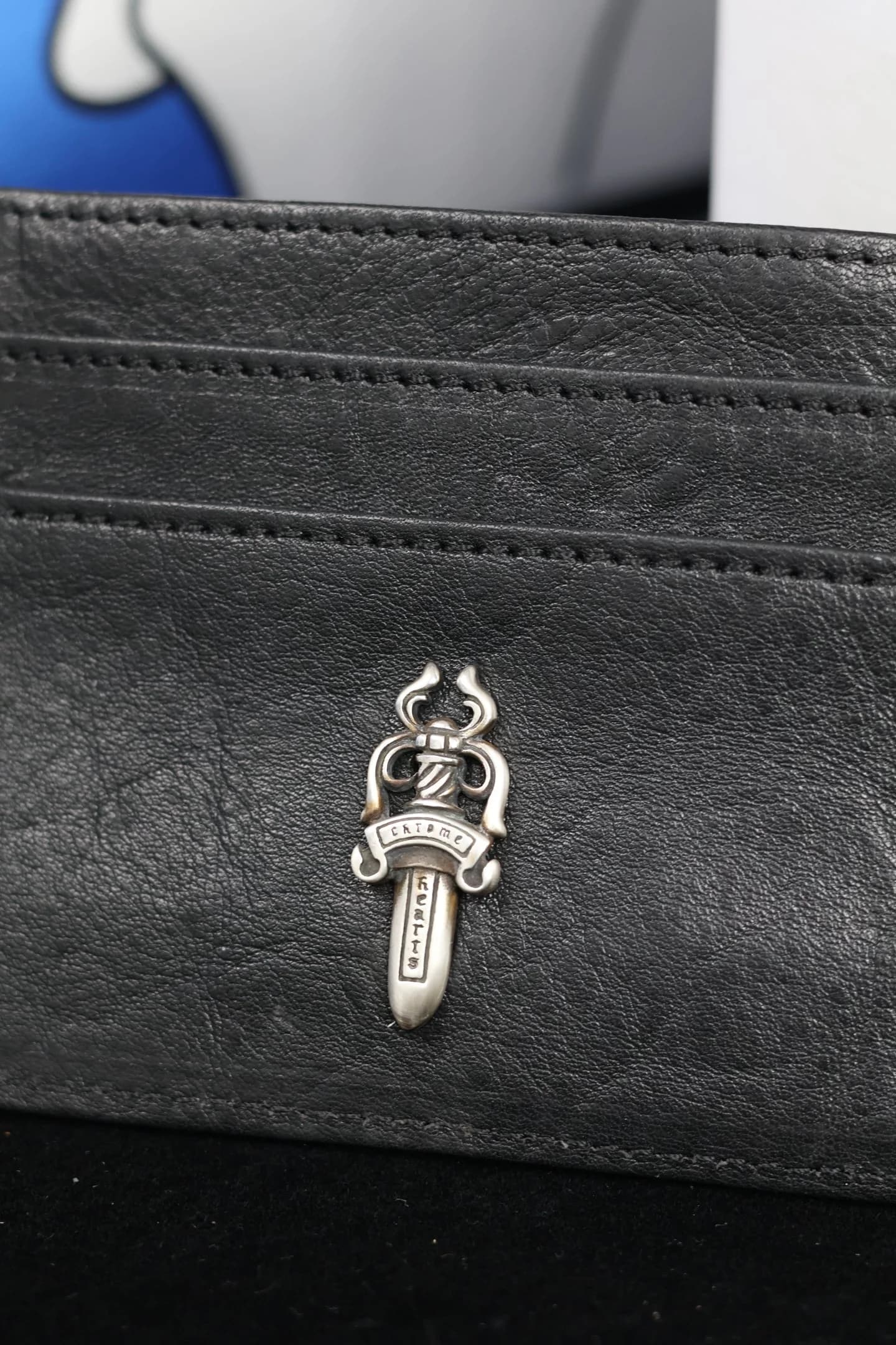 Крупный план серебряной детали Dagger и фактуры кожи картхолдера