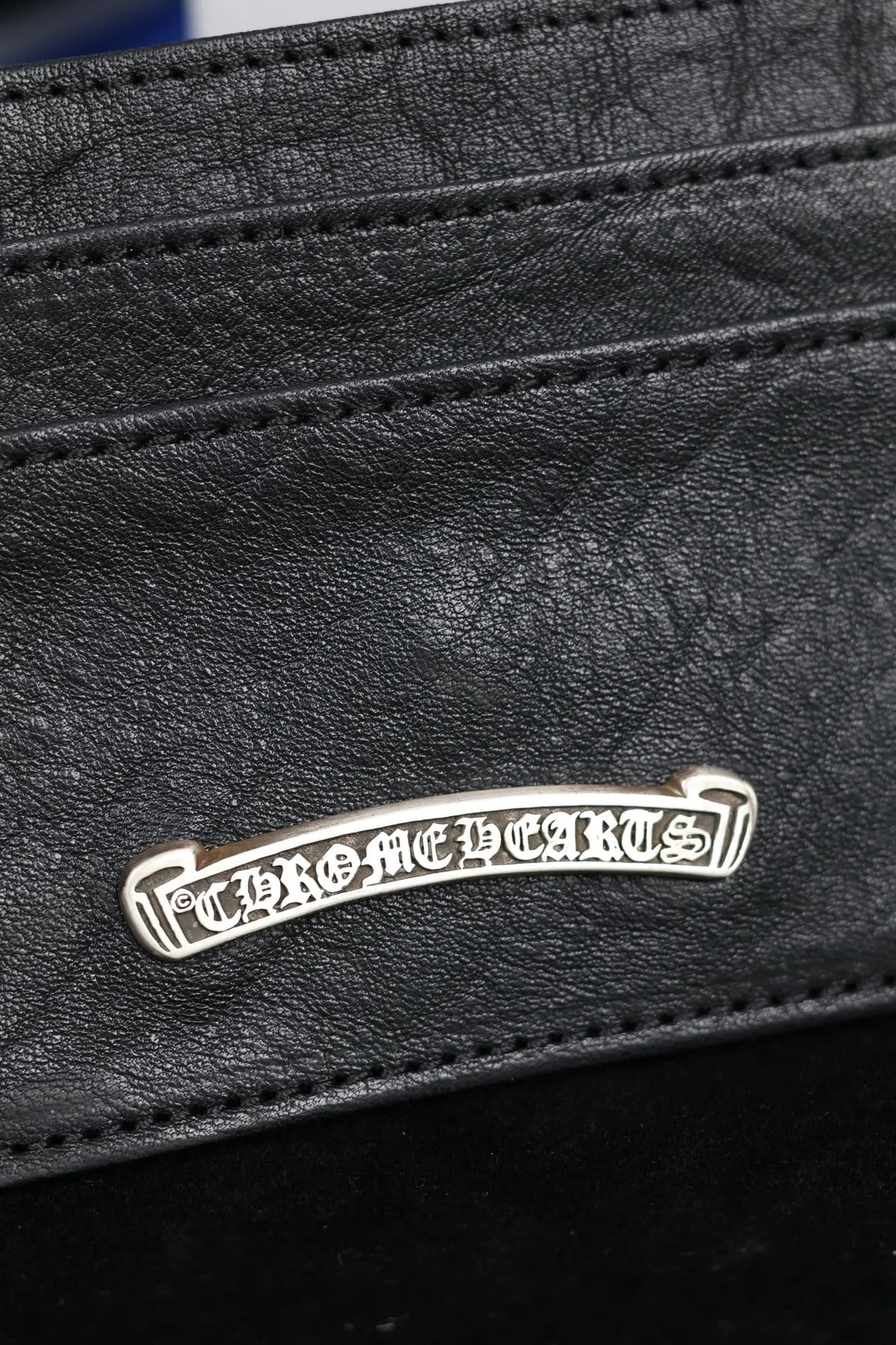 Крупный план серебряной планки с гравировкой Chrome Hearts на слоте для карт