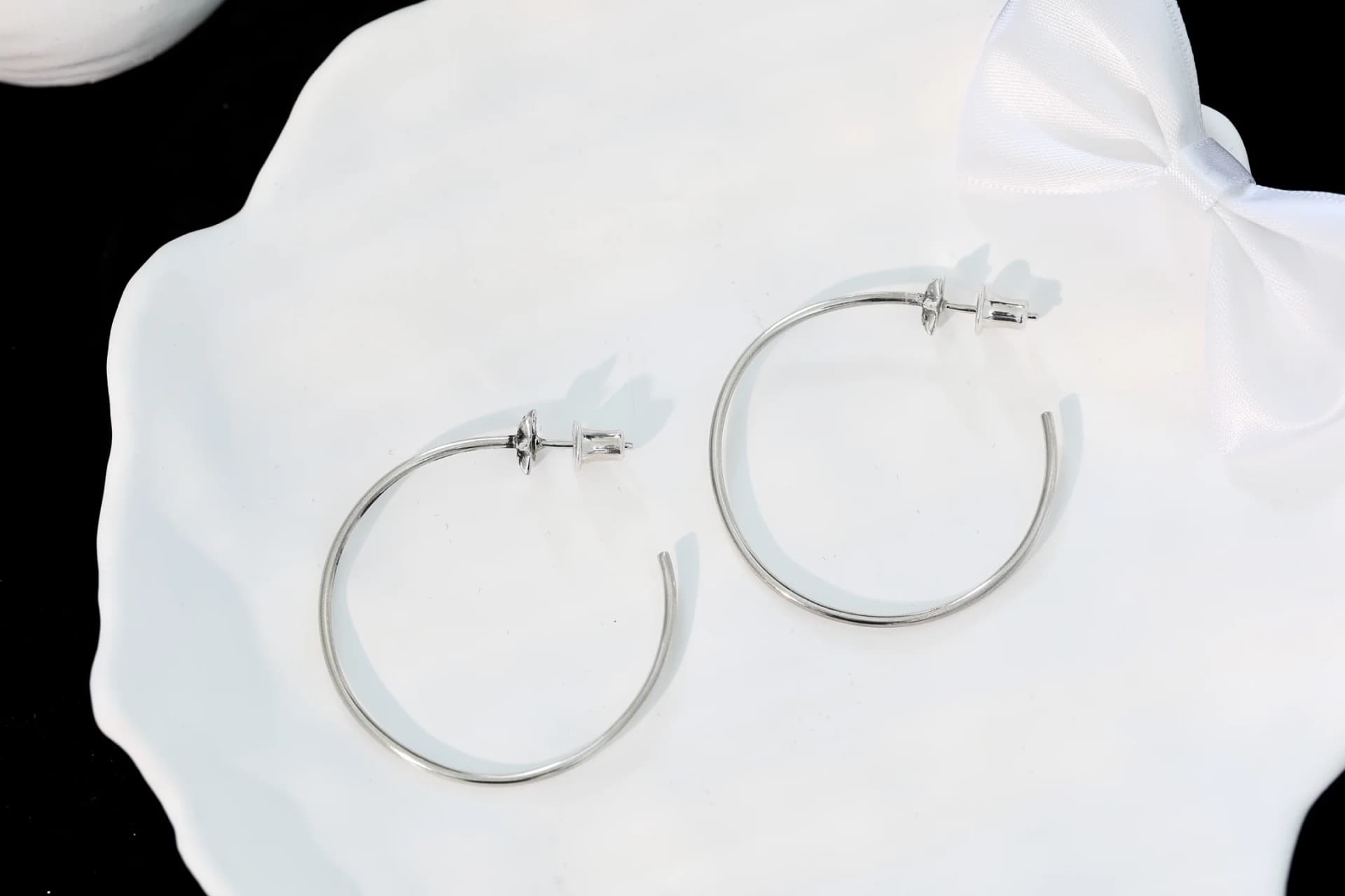Пара серег-колец Chrome Hearts Star на белой декоративной тарелке