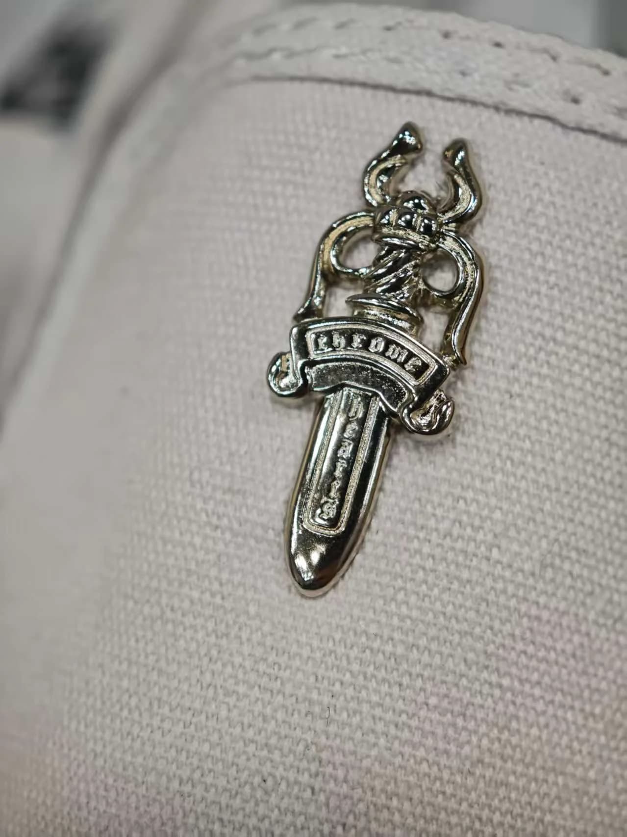 Деталь серебряной фурнитуры в виде кинжала Chrome Hearts на кедах Vans