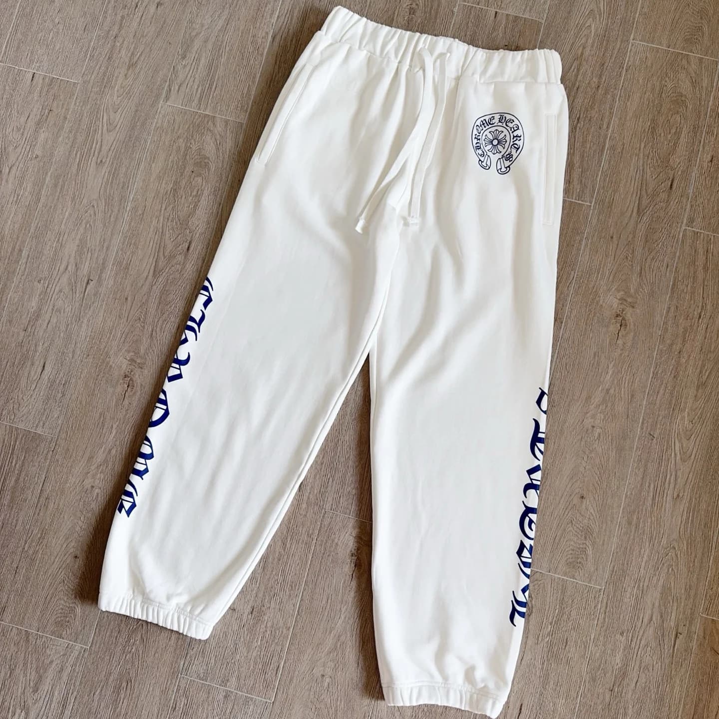 Белые спортивные штаны Chrome Hearts, вид спереди под углом