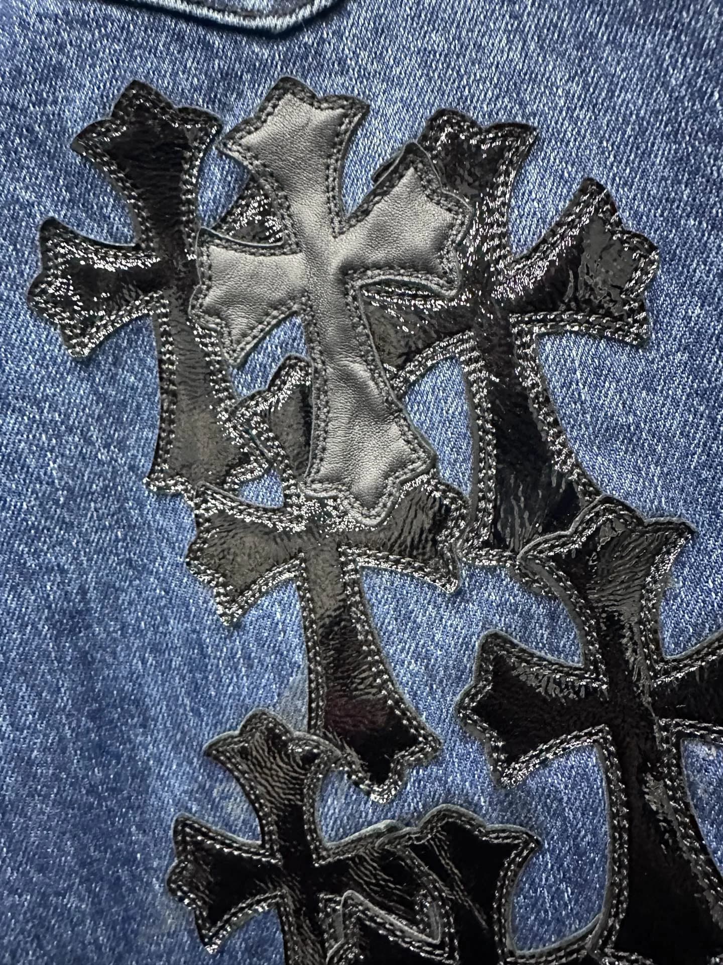 Кожаные патчи в виде крестов на джинсах Chrome Hearts, крупный план