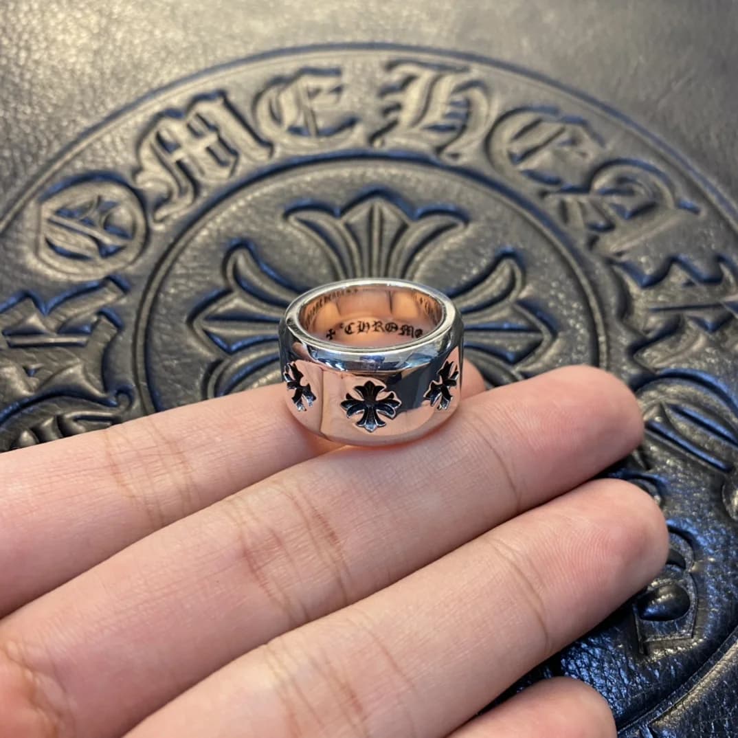Широкое серебряное кольцо Chrome Hearts с резными крестами в руке