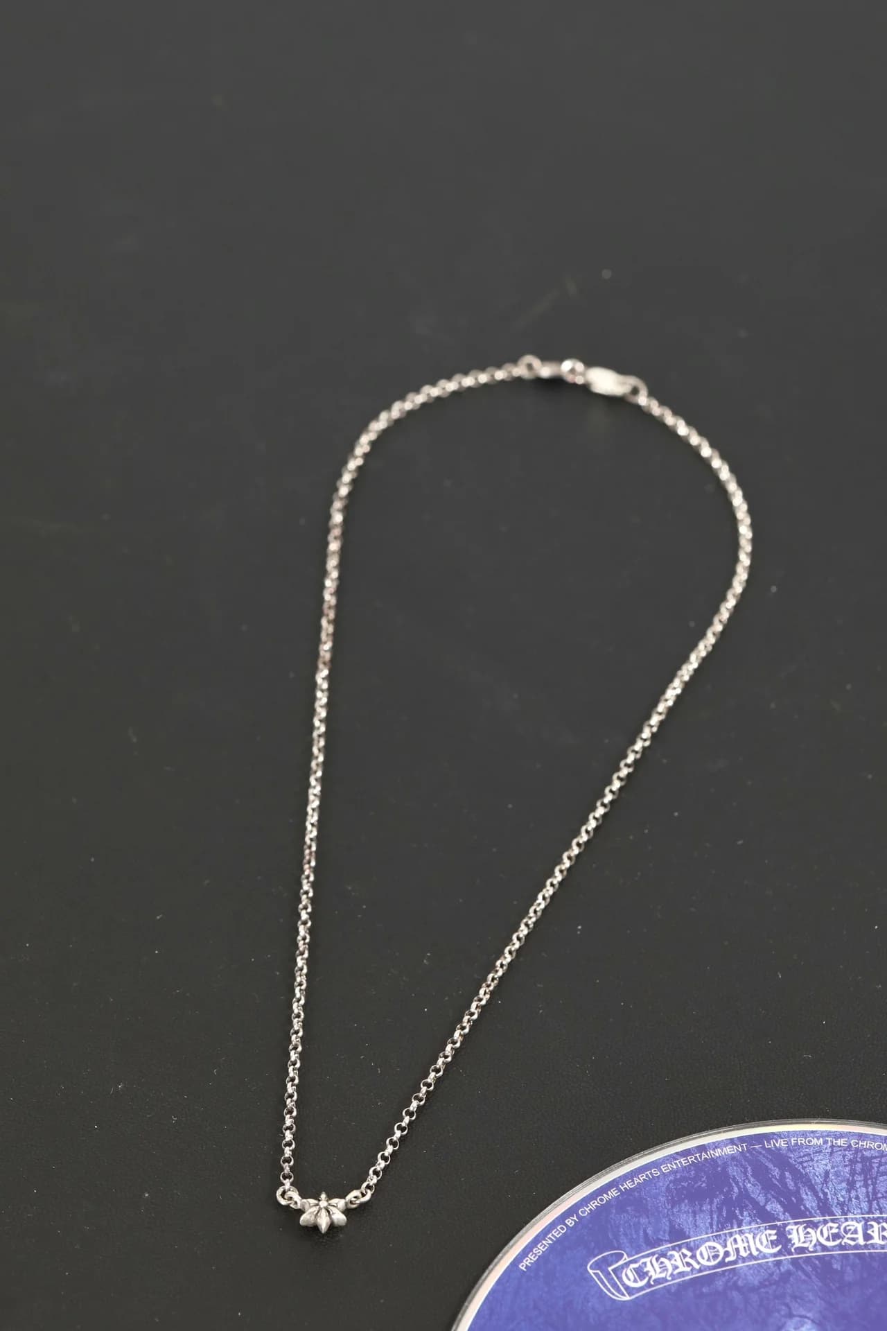Серебряное колье Chrome Hearts с подвеской-звездой на тёмном фоне