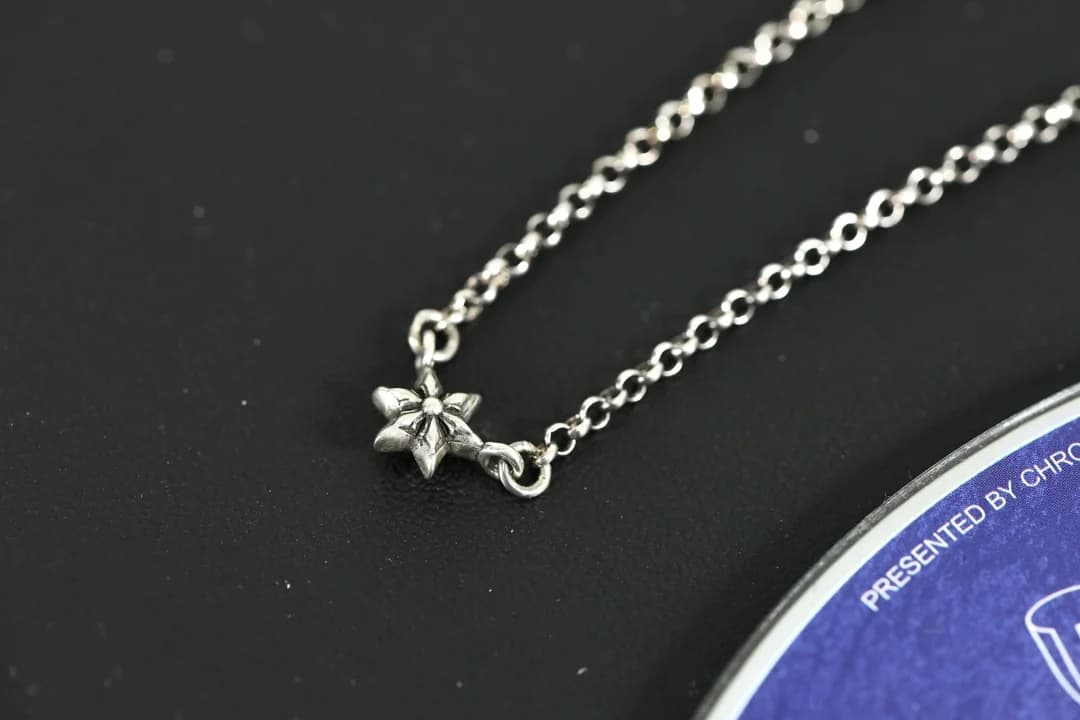 Деталь миниатюрной серебряной звезды и звеньев колье Chrome Hearts