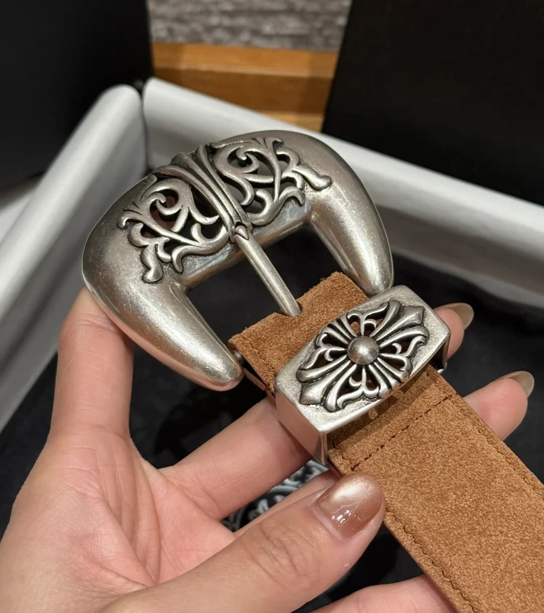 Крупный план резной пряжки и тренчика с крестом Chrome Hearts