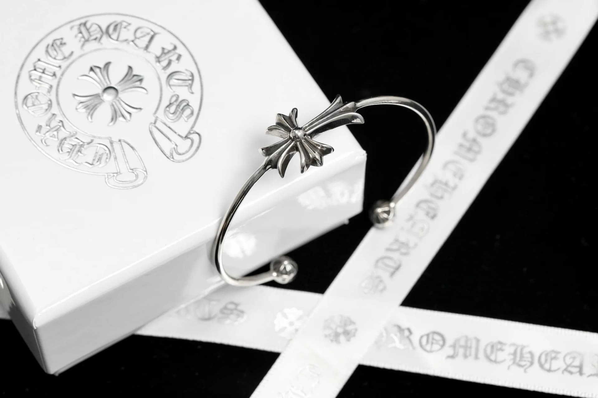 Серебряный браслет-кафф Chrome Hearts с крестом рядом с фирменной коробкой