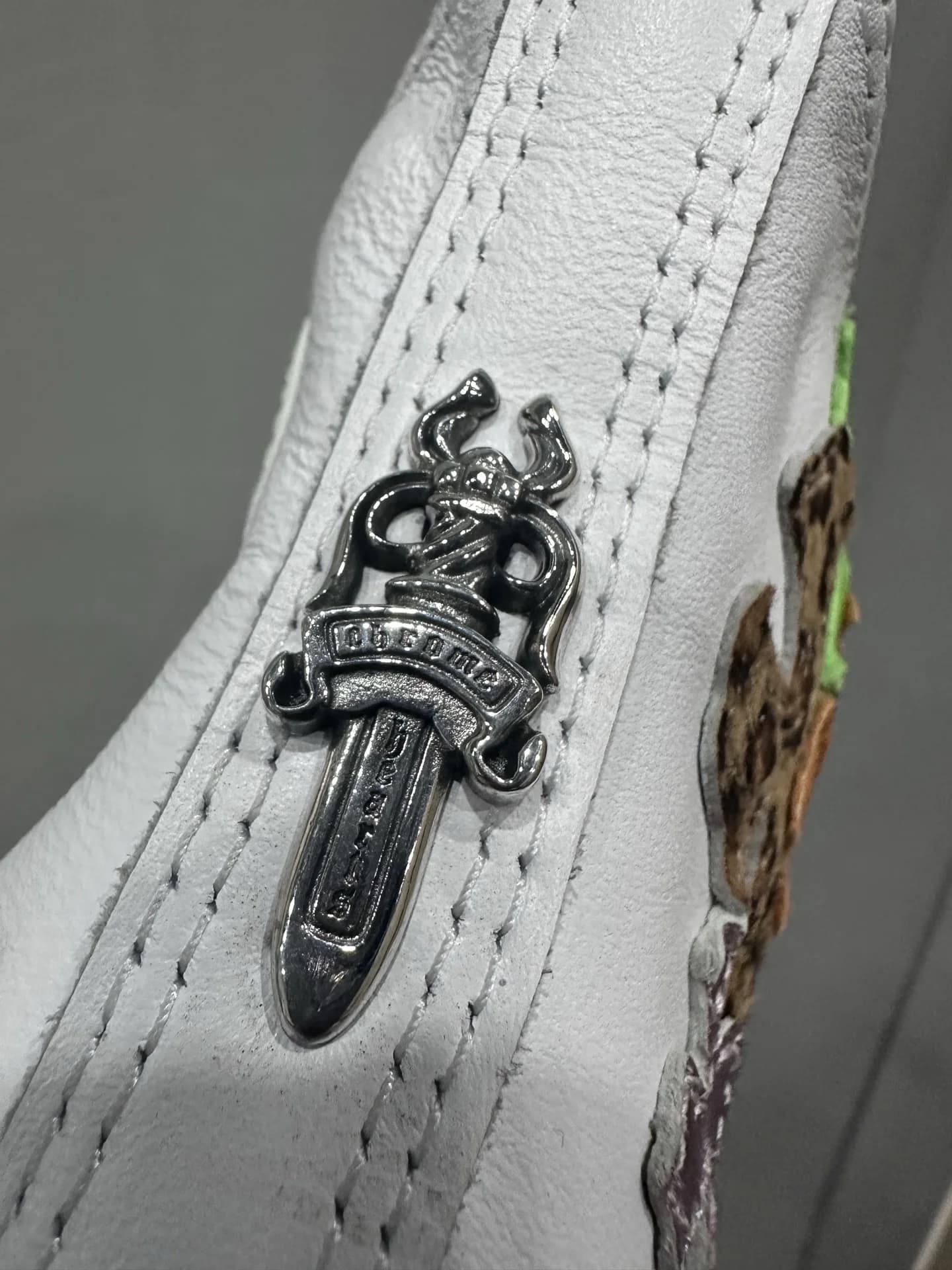 Серебряная фурнитура в виде кинжала на заднике кед Chrome Hearts