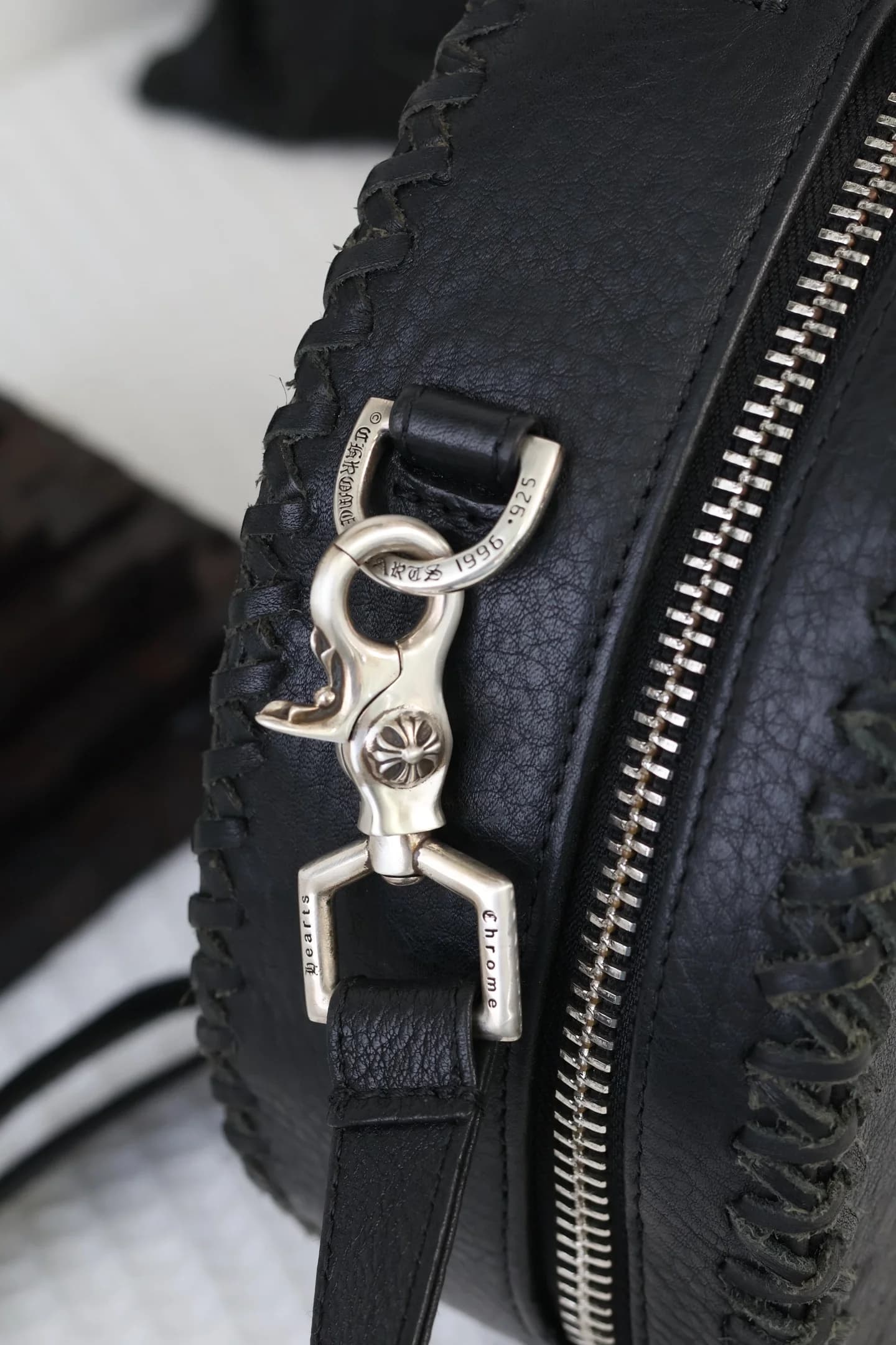 Фирменный серебряный карабин с гравировкой Chrome Hearts, прикрепленный к креплению сумки
