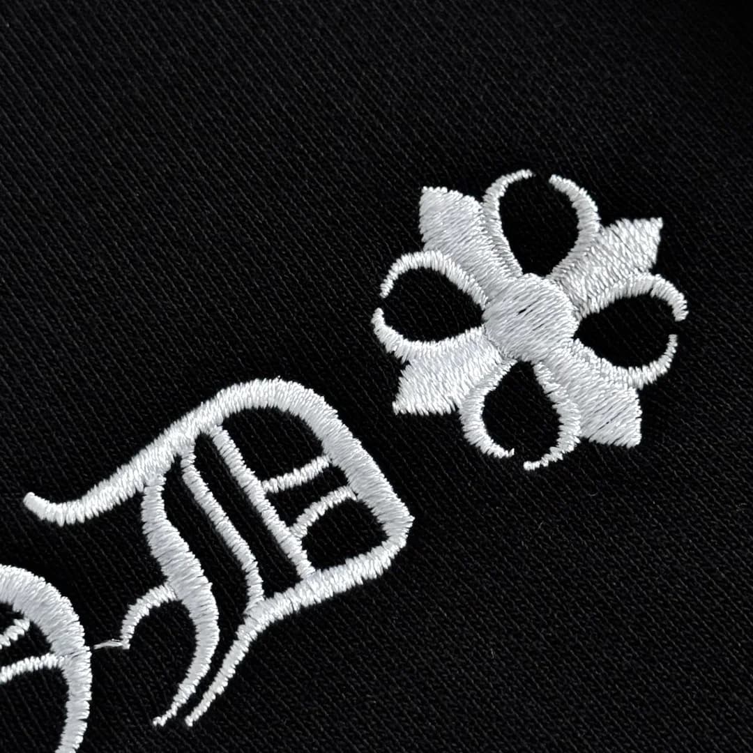 Крупный план белой вышивки с готическим шрифтом Chrome Hearts