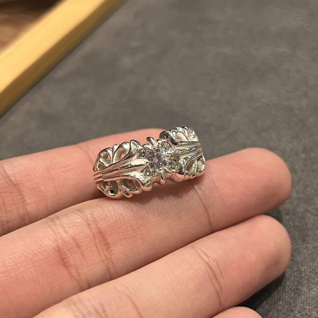 Крупный план серебряного кольца Chrome Hearts с инкрустацией камнями