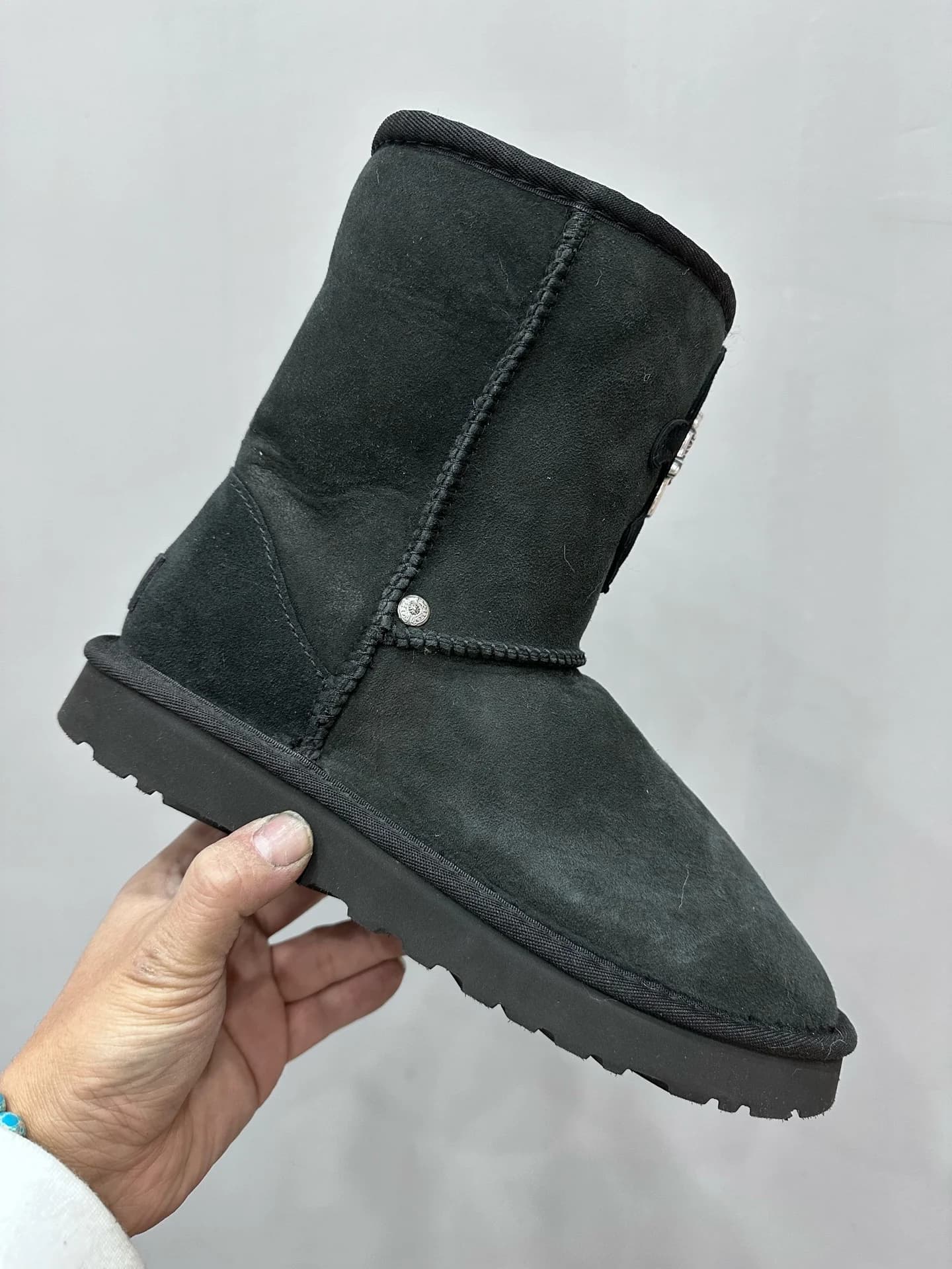 Вид сбоку на черные сапоги-угги Chrome Hearts x UGG