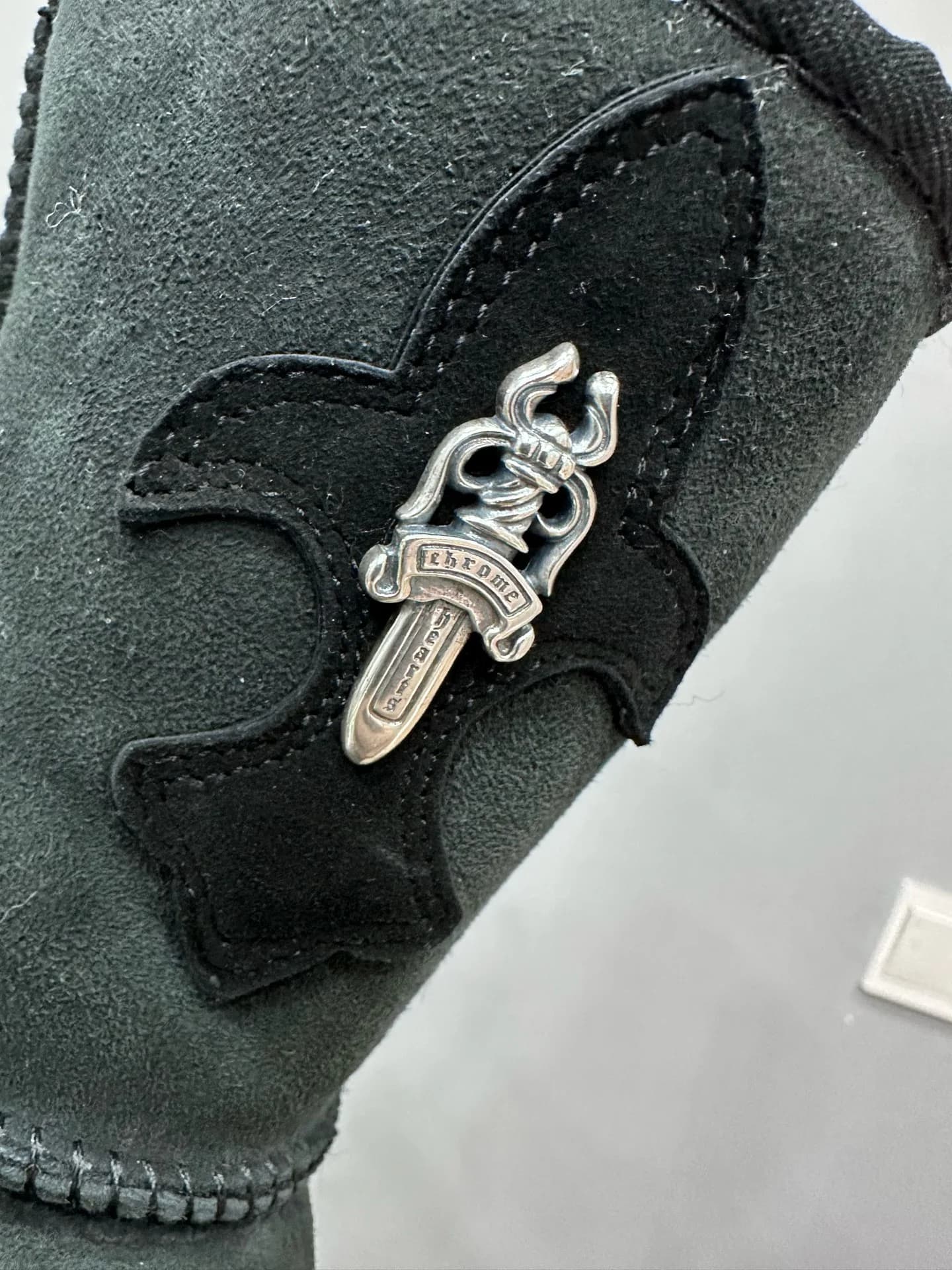 Деталь серебряного кинжала на кожаной нашивке сапог Chrome Hearts x UGG