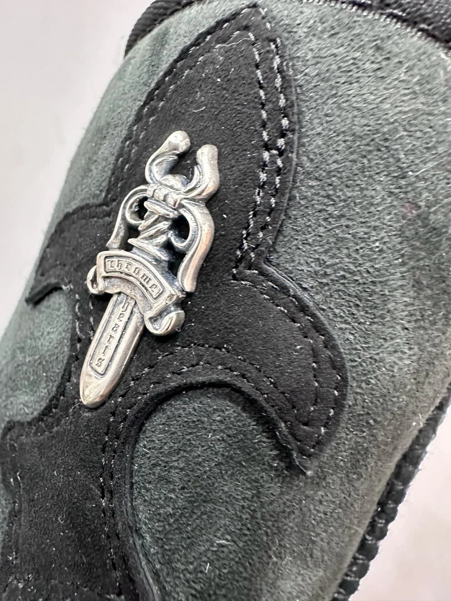 Крупный план серебряной фурнитуры в виде кинжала Chrome Hearts