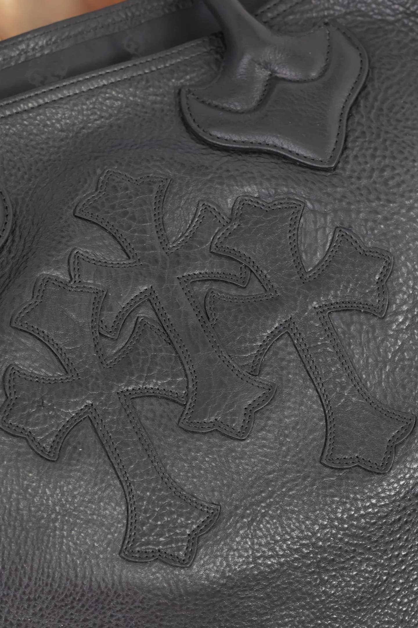 Крупный план кожаных нашивок в виде крестов Chrome Hearts