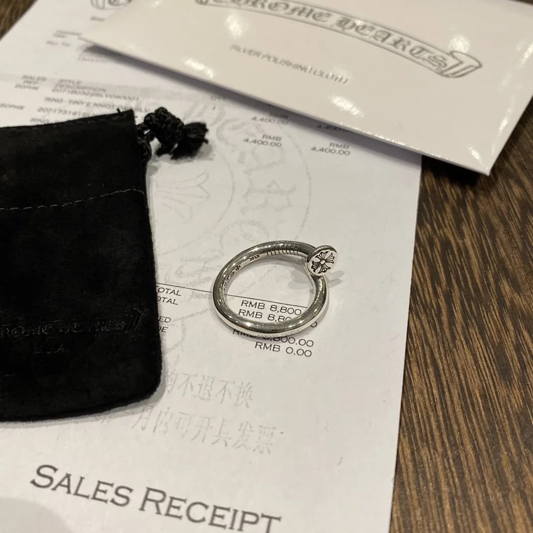 Кольцо в виде гвоздя Chrome Hearts Nail на фоне фирменных документов