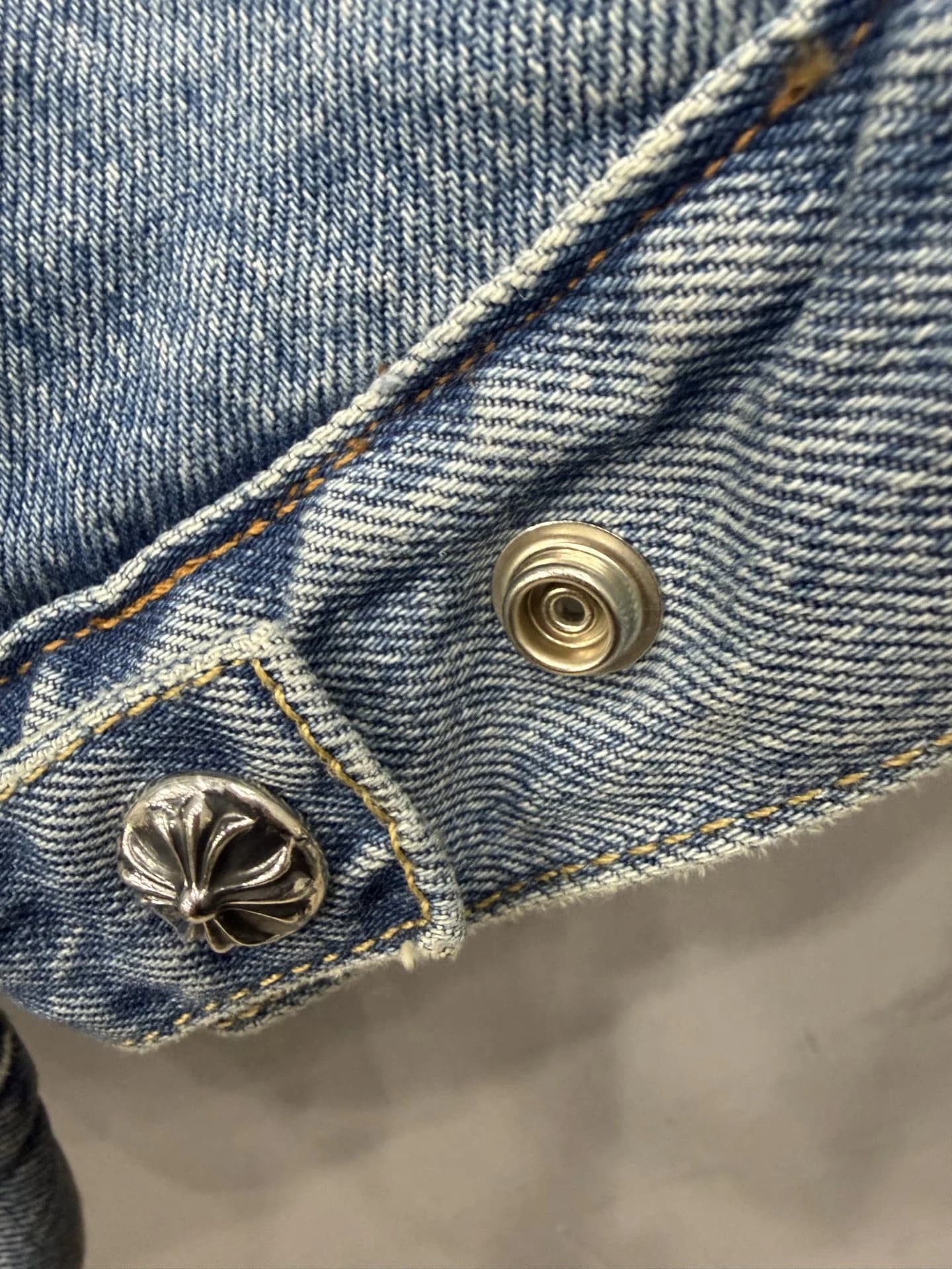 Металлическая пуговица с гравировкой Chrome Hearts на нижней кромке куртки