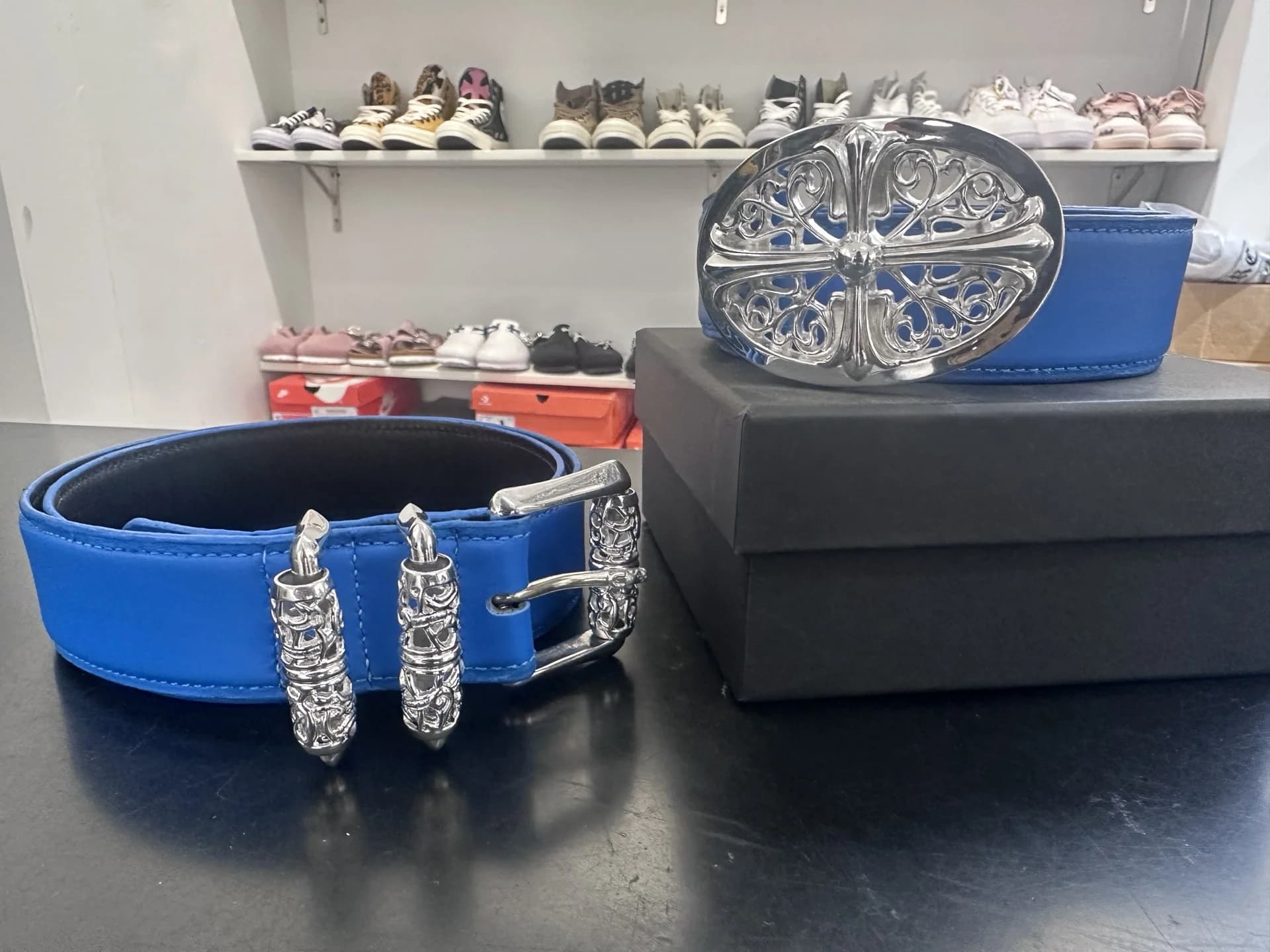 Синий ремень Chrome Hearts в свернутом виде рядом с коробкой