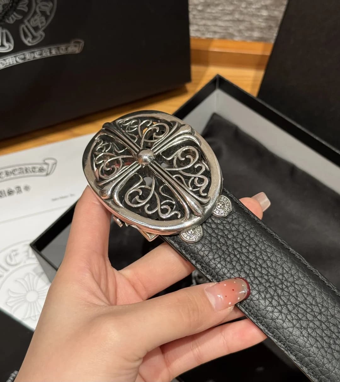 Крупный план овальной пряжки Chrome Hearts с ажурным готическим крестом