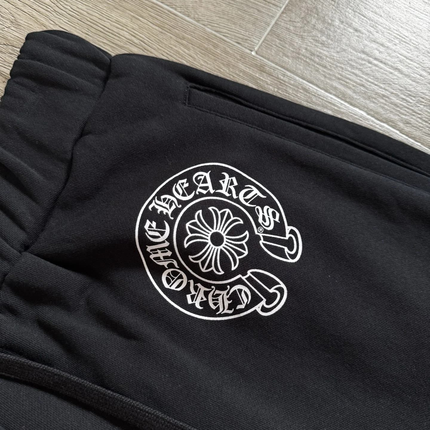 Белый принт-логотип в виде подковы Chrome Hearts на бедре