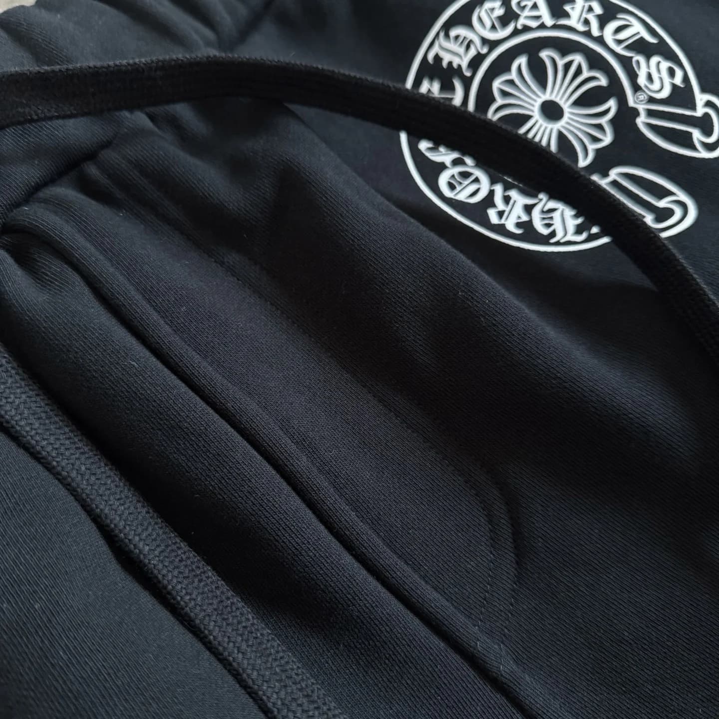 Эластичный пояс на кулиске и принт в виде подковы на штанах Chrome Hearts