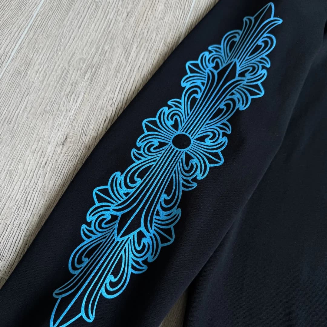 Крупный план рукава с синим готическим узором Chrome Hearts