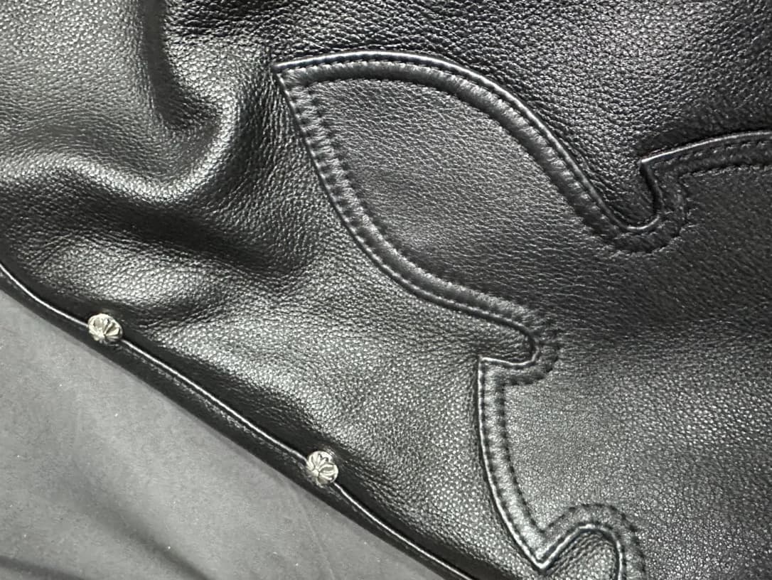 Боковой шов кожаных брюк Chrome Hearts с серебряными заклепками-крестами