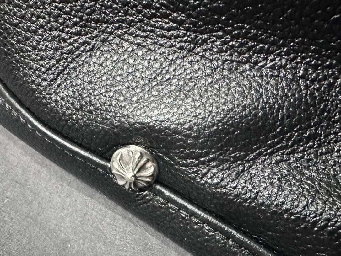 Крупный план серебряной заклепки в виде креста Chrome Hearts