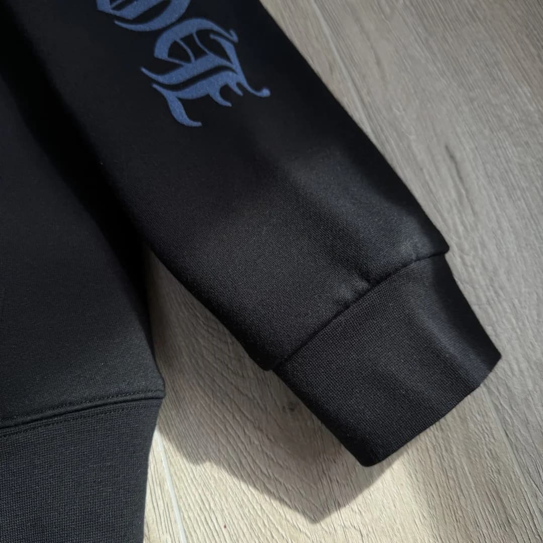 Деталь черного принта на белом трикотаже Chrome Hearts