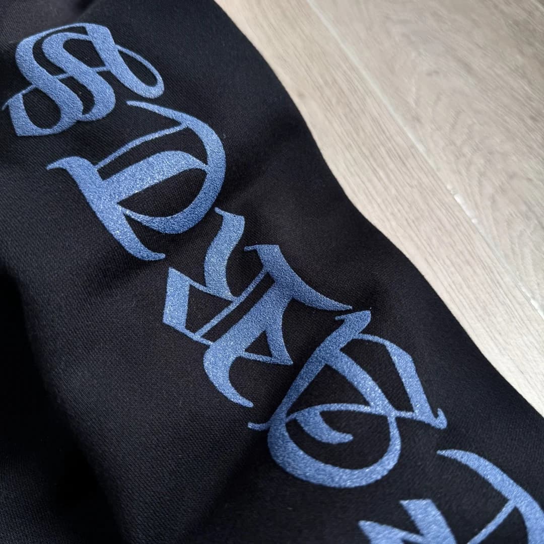 Крупный план готического принта на рукаве зип-худи Chrome Hearts