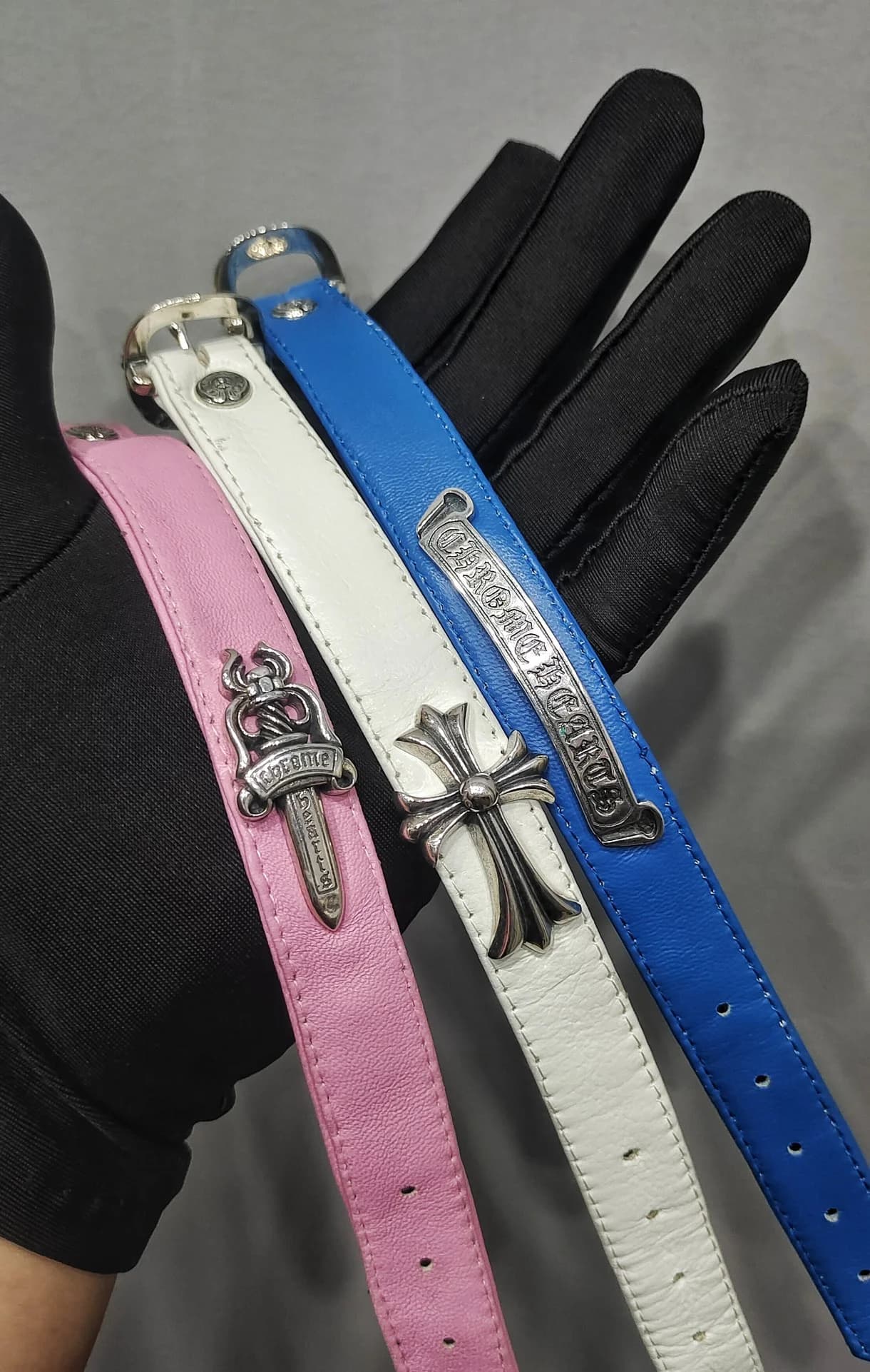 Три кожаных браслета-ремешка Chrome Hearts в руке