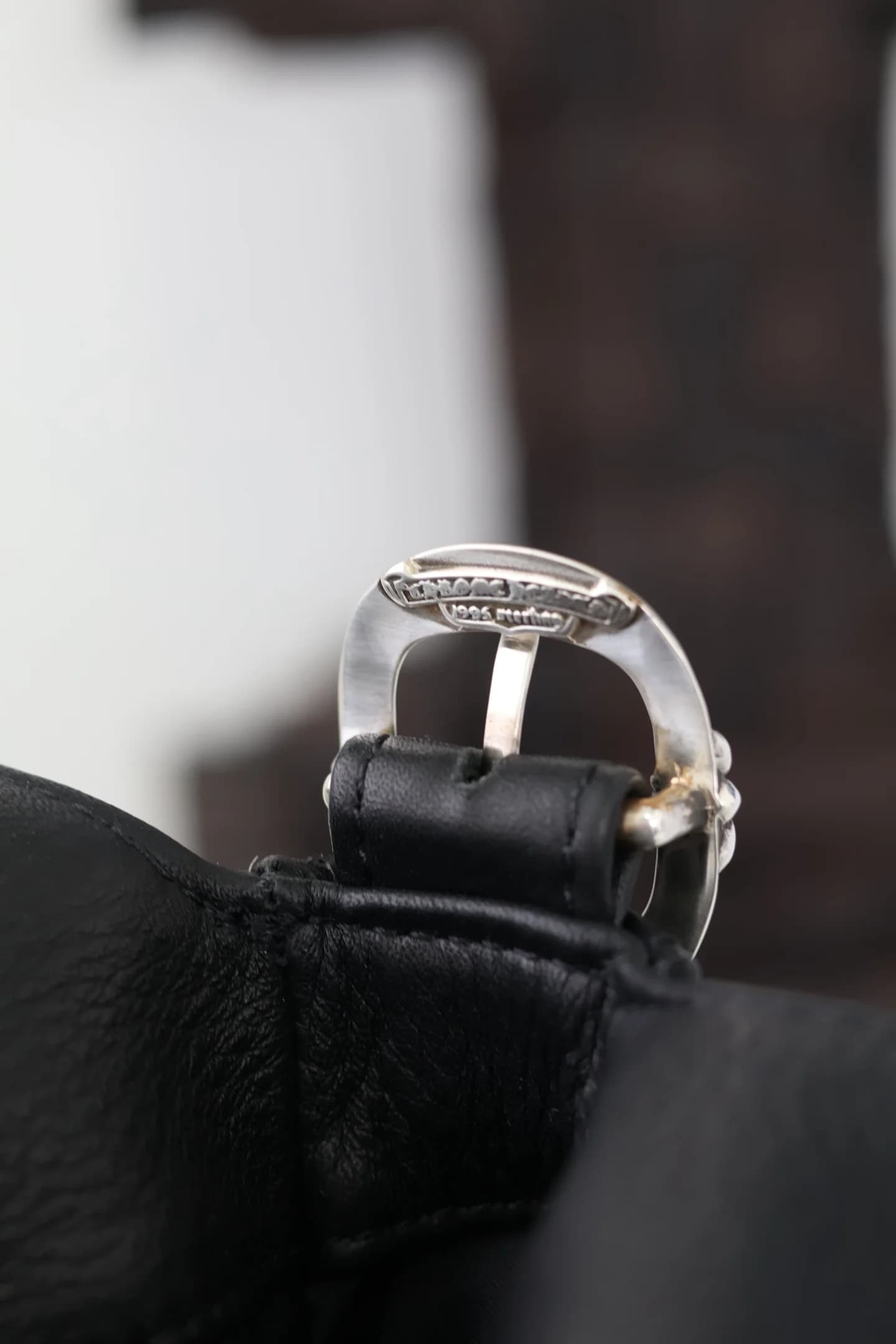 Гравировка бренда на серебряной пряжке сумки Chrome Hearts
