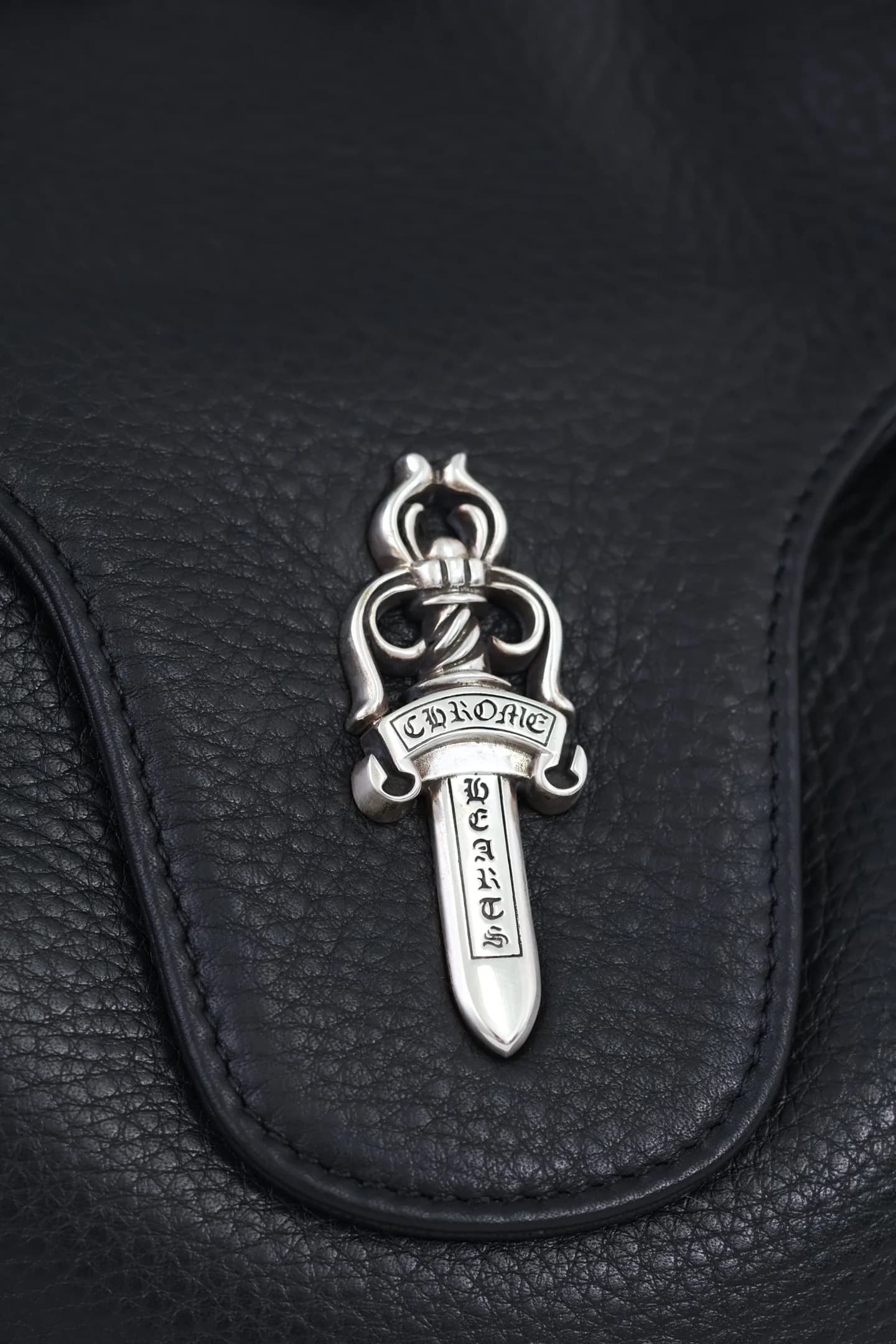 Крупный план серебряной детали Dagger 925 пробы на клапане сумки
