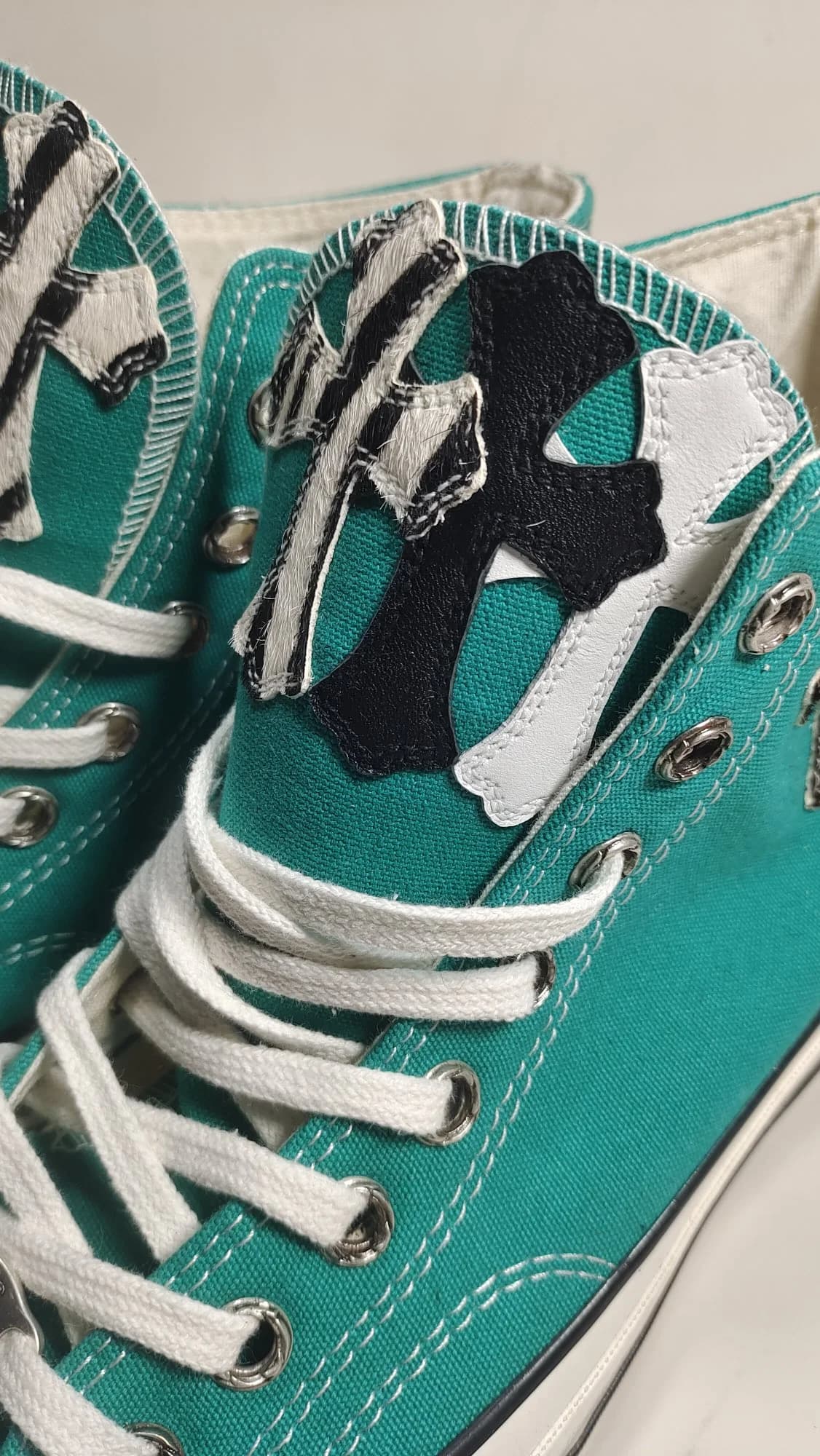 Деталь язычка кед Chrome Hearts x Converse Chuck 70 High с нашивкой в виде креста