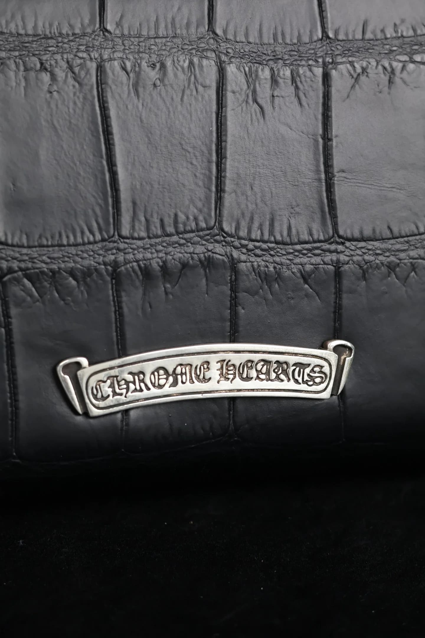Крупный план серебряной планки с гравировкой Chrome Hearts
