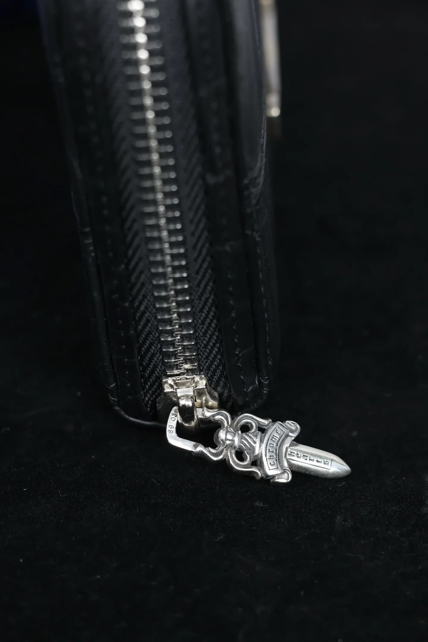 Крупный план внешней молнии с серебряным замком Dagger Chrome Hearts