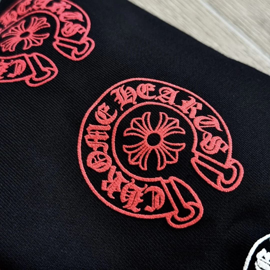 Крупный план красного принта на рукаве зип-худи Chrome Hearts