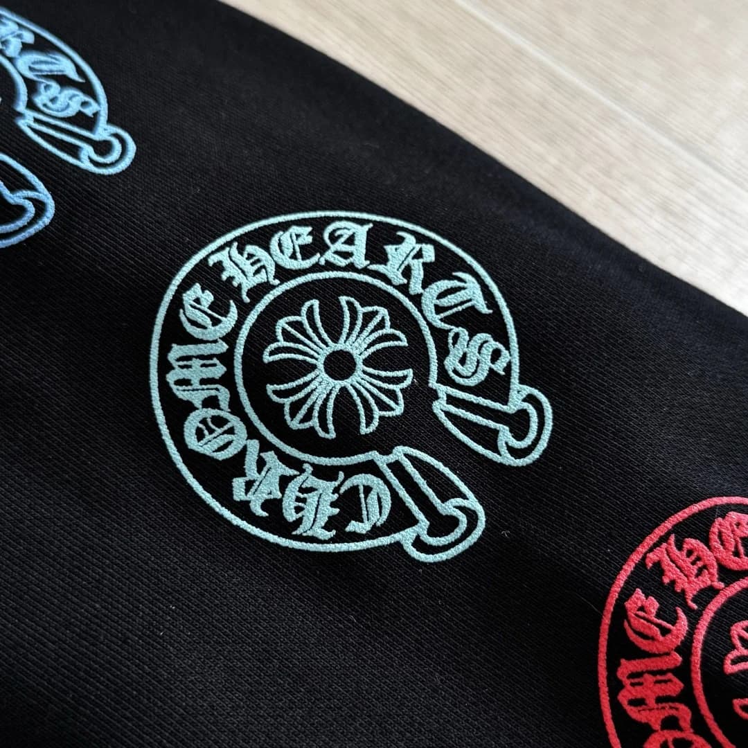 Крупный план бирюзового принта на рукаве зип-худи Chrome Hearts