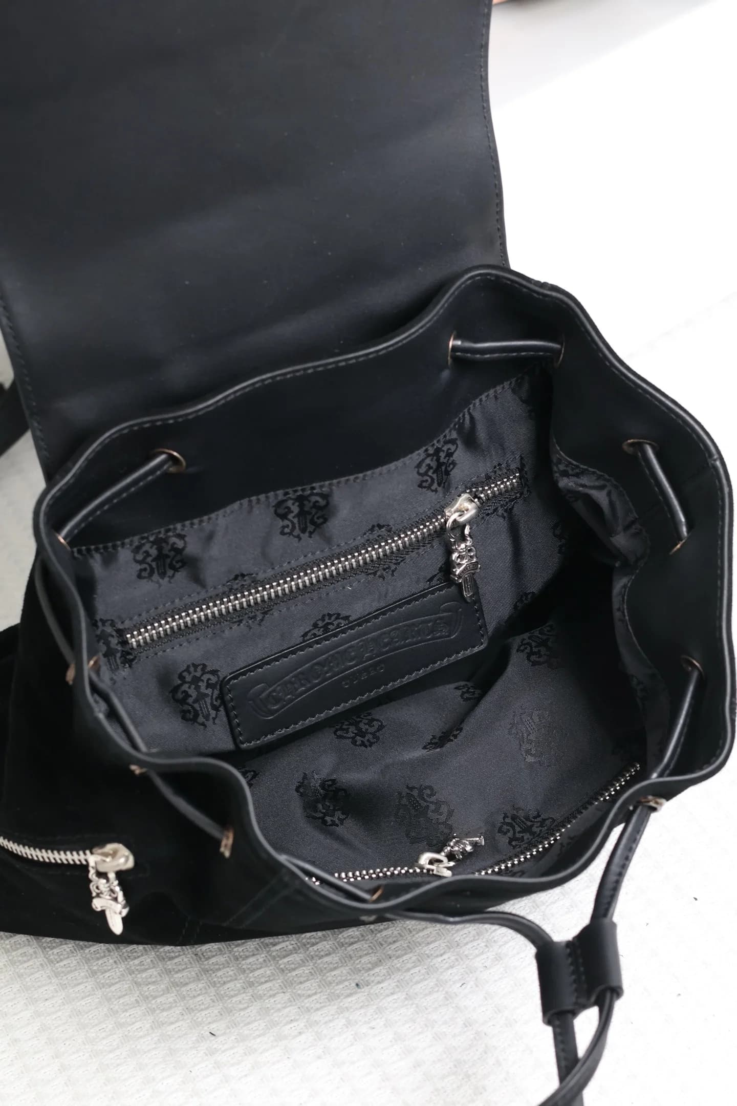 Внутреннее отделение рюкзака Chrome Hearts с фирменной подкладкой и карманом на молнии