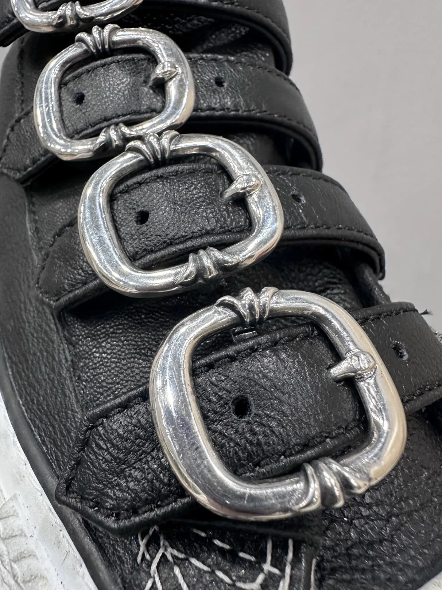 Крупный план металлических пряжек на ремешках кед Chrome Hearts