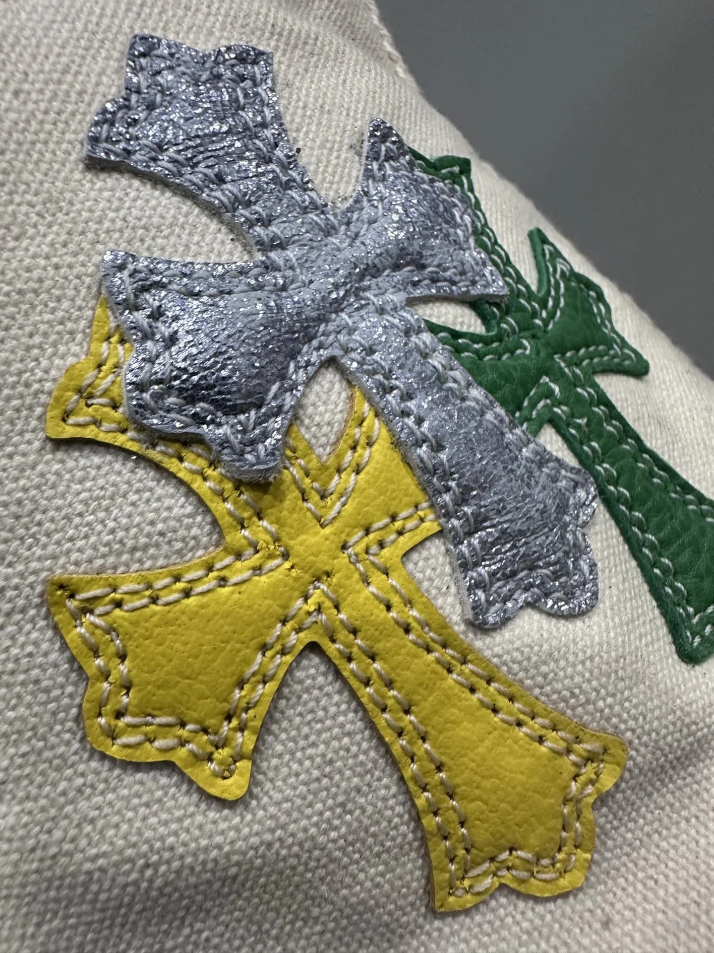 Деталь кожаных нашивок в виде крестов на кедах Chrome Hearts x Converse